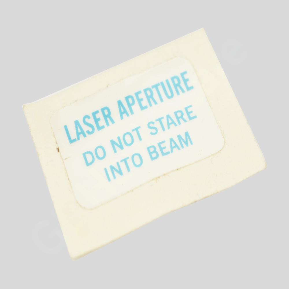 LASER APERTURE, DONT STARE INTO BEAM ADHESIVE BACKED LASER APERTURE, DONT STARE INTO BEAM ADHESIVE BACKED